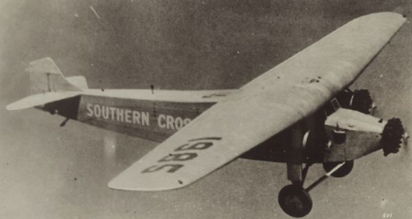 Right side view of a Fokker F-VII Trimotor in flight. The wing identifier read: "1985." This airplane, called the "Southern Cross," was flown in the spring of 1928 from the United States to Australia in the first trans-Pacific flight. The journey covered 7,400 miles with 83 hours and 35 minutes spent in the air. The crew included Captain Charles Kingsford Smith, Flight Lieut. Charles Ulm, navigator Harry Lyon, and radio operator James Warner.