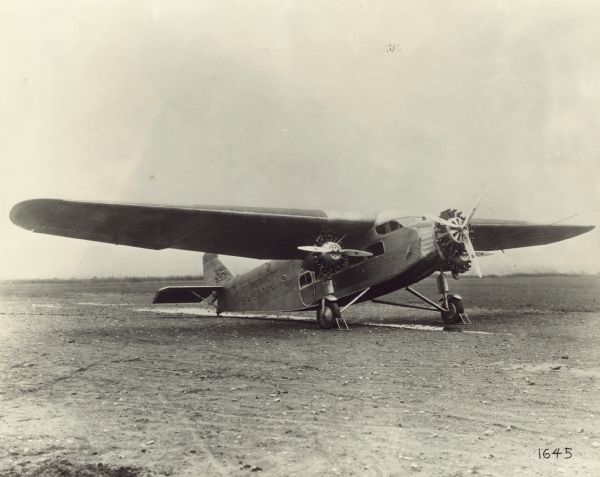 Three-quarter view from front right of a Ford 4-AT-B Trimotor sitting on a runway. The tail identifier reads: "NX 4542." This airplane was one of three used in Richard Byrd's 1928 expedition to the South Pole. It was named "Floyd Bennett" after a recently deceased pilot that partook in Byrd's previous expeditions. Painted on the side are: "Byrd Antarctic Expedition" and "Floyd Bennett."