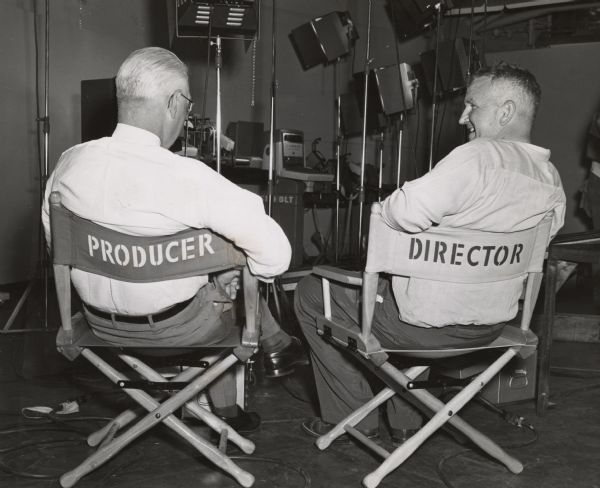 Sid Boyum, at right in the director's chair, and a Gisholt executive on the left. They are sitting while working on a Gisholt film.
