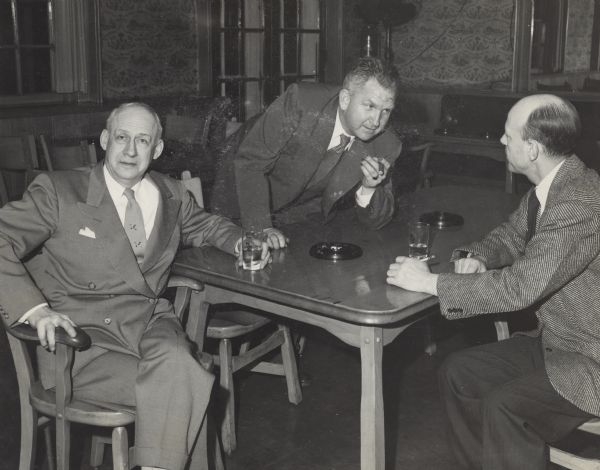 Sid and two friends in tavern. (Possibly related to Ducks, Unlimited.) The man sitting on the left has a neck tie decorated with ducks. Sid's nails are stained, probably with pyrogallol, a staining agent used in the development of film.