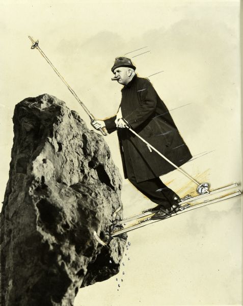 Composite of two images: one a photograph of a rock, the other a cutout photograph of Sid on skis. The image is depicting Sid flying through the air on snow skis, which have run into a huge rock. The tips of the skis have broken off and parts of the rock are falling off in pieces. Sid is chewing on his signature cigar and is holding a ski pole up in the air. Marks drawn onto the image portray speed.