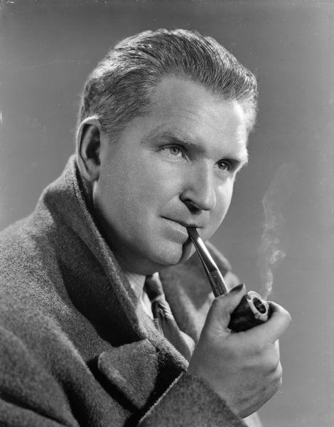 Quarter-length portrait of Sid smoking pipe.