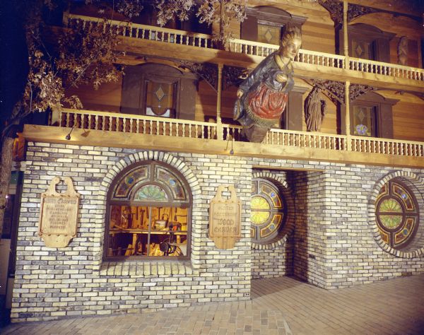 Exterior view of the Günter Holtzkopf Wood Carving Studio. A large ship's figurehead of a woman extends out from the balcony above the entrance. This image was used in the original brochure for the House on the Rock. 
