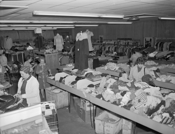 Elevated view of women sorting out donated clothes in St. Vincent's Thrift Shop.  