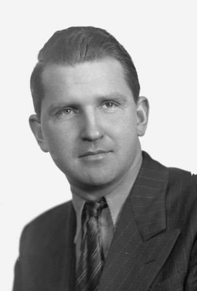 Quarter-length studio portrait of Sid Boyum wearing a suit and tie.