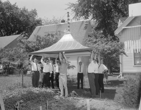Sid and some friends carrying the roof for his pagoda, ready to be installed. On the right with hand on hip is Sid's friend Russell Pratt Metcalf.