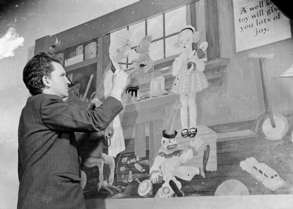 Sid Boyum painting a Works Progress Administration (WPA) mural of a toy shop. The 1940 census lists Sid as an artist/government worker for the Toy Loan Program, which was started by the WPA in the spring of 1940.