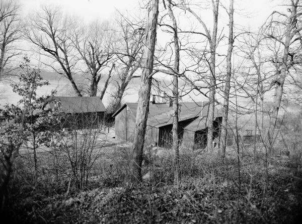 View of Johnson duck shack at old Cherokee Marsh amidst trees and shrubs. The site was where plans for the Ducks Unlimited southern Wisconsin chapter were formulated.