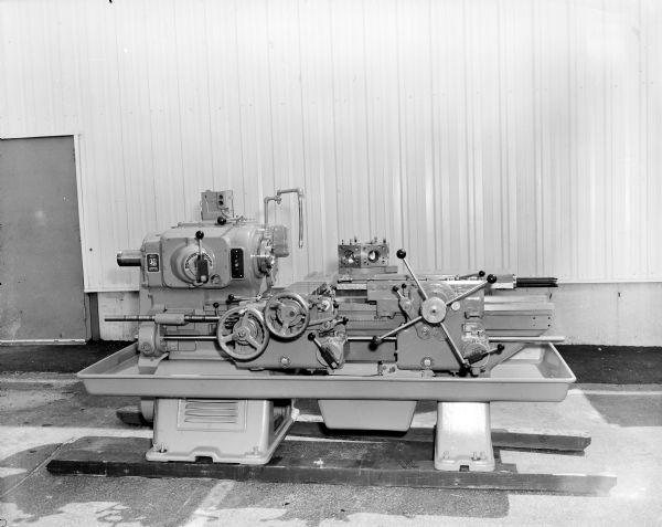 A large piece of machinery is sitting on planks outdoors at the Gisholt factory.