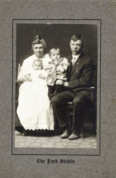 Group portrait of Sid's family: Severt and his mother (?), with Sid in the center, and his younger sister Bernice on the woman's lap.