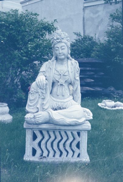 Sculpture of Avalokiteshvara / Kannon / Guanyin (also known as the bodhisattva of compassion and mercy) in Sid's backyard. The figure depicted as either male or female is recognized by the body of the Buddha in the headress. 