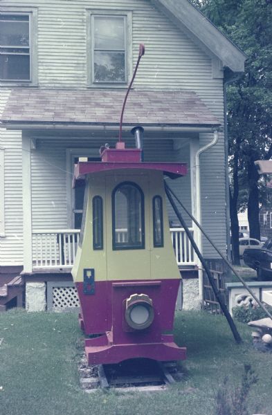 Toonerville Trolley car in Sid's backyard on Waubesa Street. The Smiling Mushroom sculpture can be seen to the right of the car. 
