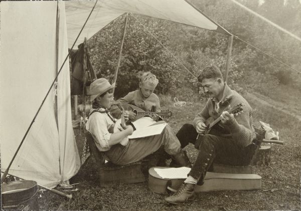 Campers, L-R: Clay Judson, Carl (Charles) Greene, and Bill Marr playing mandolins at their campsite.