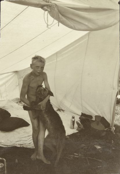 Carl hugging his dog Di in a tent at the group's camp.
