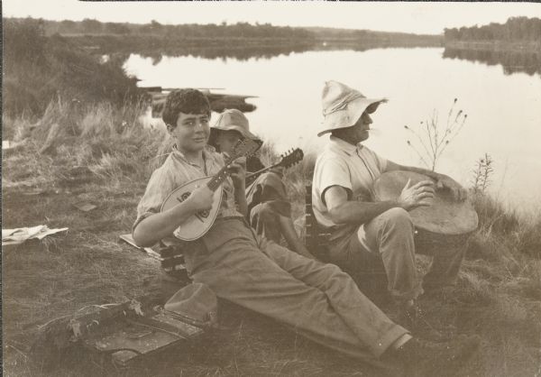 From left to right are Clay Judson, Carl, and Doc Copeland playing music by the St. Croix River. Doc purchased the drum at a Native American village.