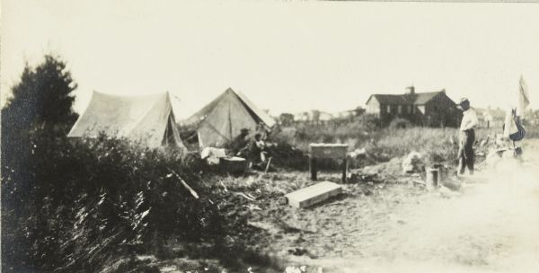 The Gang's first camp of the trip, set up near Glidden. There are two tents set up in a field, and a house is in the far background.