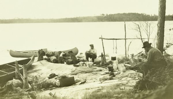 The Gang eating their lunch by French Lake. Their canoes are pulled up on the shoreline.