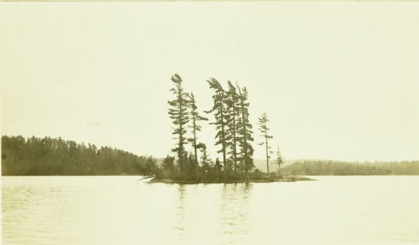 A small island with tall trees in Kasakokwog Lake, which was called Anna Lake by the rangers. The far shoreline is in the background.