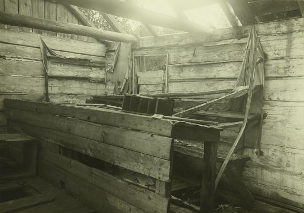 The ruins of a wooden counter and shelves in the abandoned Mac Laren's Hudson's Bay Company Store near Sturgeon lake. A portion of the roof is missing.