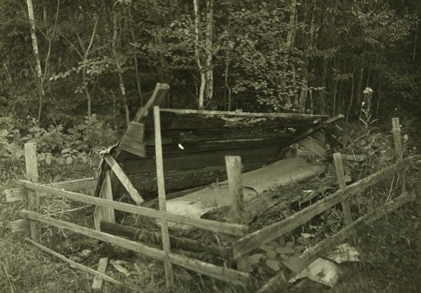 A dilapidated grave near Mac Laren's Hudson's Bay Company Store and Sturgeon Lake. The coffin is covered with birch bark. 