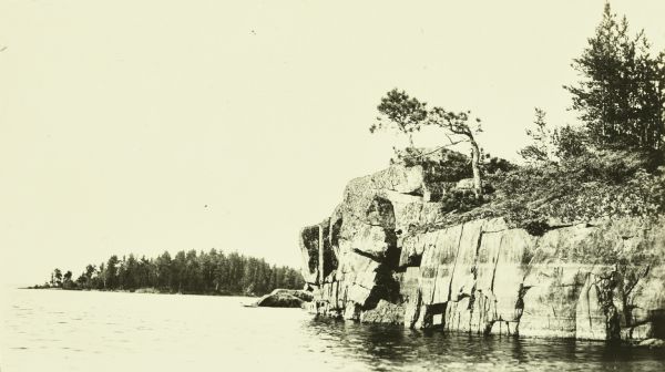 View across water towards a large rock outcropping on Rainy Lake.