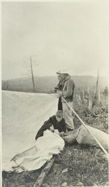 Jack, Doc, and Clay setting up a tent at their campsite.  