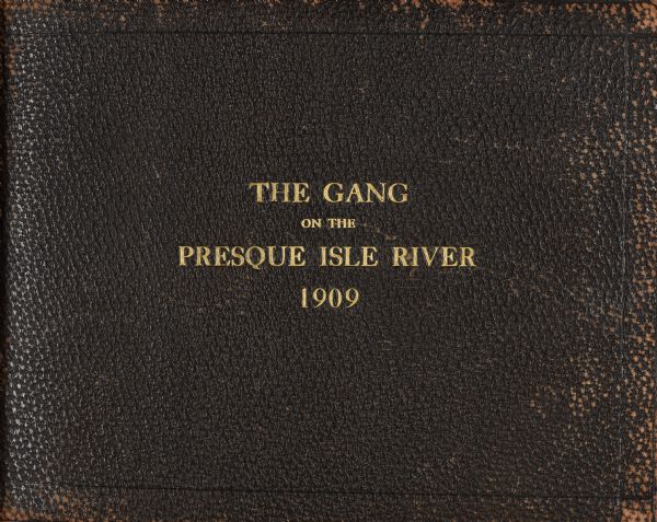 A brown leather journal cover with the title "The Gang on the Presque Isle River 1909" stamped on in gold.