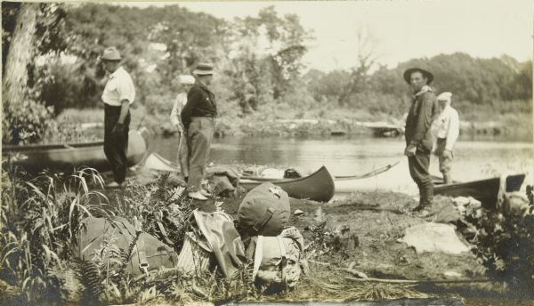 The Gang loading their travel supplies at a campsite. From left to right are: Doc Copeland, Howard T. Greene, Bill Marr, Fred Carr, and Howard Greene.