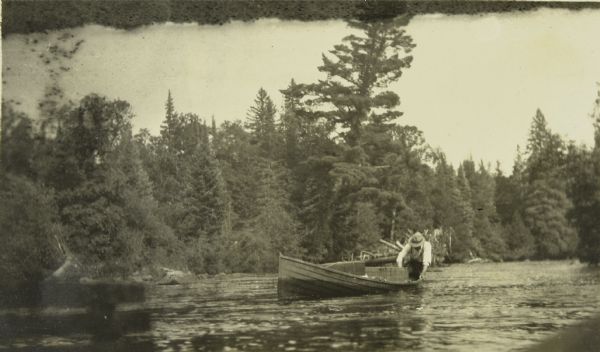 One of the men launching a wannigan onto the Presque Isle River.