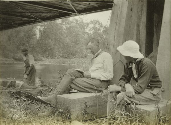 Howard Greene (center) writing in the Presque Isle River Travel Journal at camp. Howard T. is sitting next to him. 