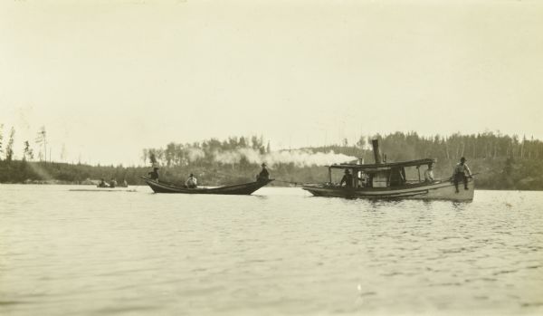 A Steam Tender towing a bateau on a lake (probably Basswood Lake).
