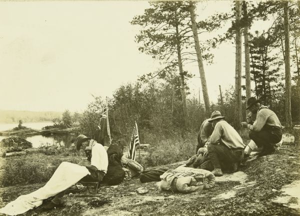 The Gang stop for a lunch break between Crooked and Iron Lakes. There is an American flag and another flag displayed among their supplies.