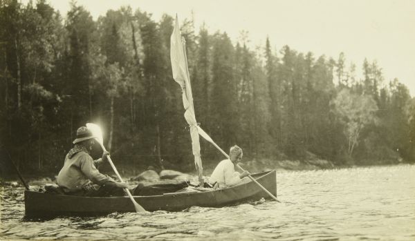 Bill Marr, on the left, and Carl, on the right, paddling Bill's folding canoe known as The Tub. The vessel has a sail.