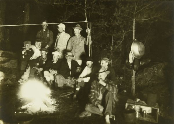 The Gang sitting around the campfire together at a camp.