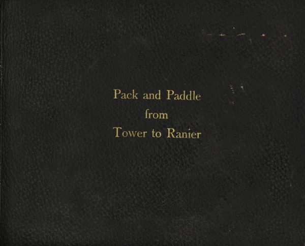 The brown leather cover of Howard Greene's travel journal. The title, "Pack and Paddle from Tower to Ranier" is stamped on the leather in gold.