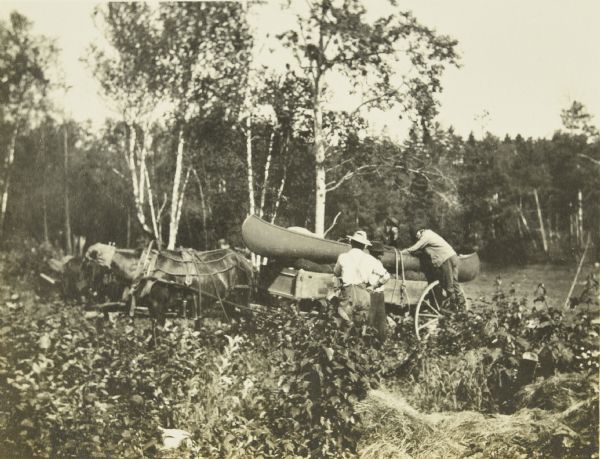 The Gang loading their canoes onto a horse-drawn wagon.