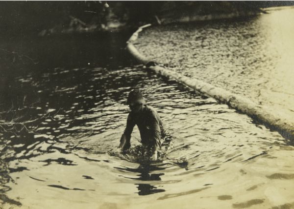 B (William Norris) standing in shallow water after falling off a log boom. This is in the Narrows between Sand Point and Namakan Lakes.