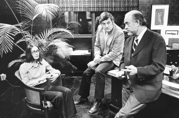 Barbara Hoffman sitting in an office and speaking with her defense attorneys, including Don Eisenberg in the plaid jacket, after she was indicted for murder. The other man is unidentified.