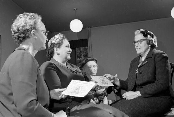 The Women's Societies of Christian Service of the Methodist Churches of Madison observed the society's 20th anniversary with a "Heritage Tea."  Dorothy Melberg, right, presents the special memberships for 1961. Recipients included, from left to right; Evalyn Harris, president of the WSCS of the First Methodist Church where the tea was held; Dorothy Nicholls, treasurer; and Betty Vaughn.