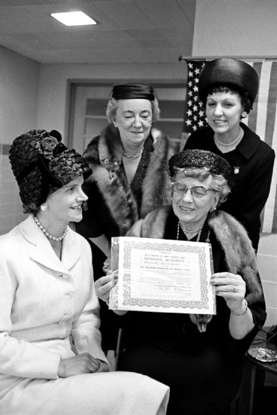 Officers of the Wisconsin Federation of Women's Clubs inspect the charter that was presented to the Mendota Woman's Club by the General Federation of Women's Clubs. It was history-making in that it marked the first time in the United States that a club composed of women patients in a mental institution was admitted to the General Foundation. The state officers pictured are: seated (left to right): Mrs. Kenneth Reed, Kenosha, and Mildred Horne, Madison, who is state president. Standing (l to r) are Mrs. Walter Karow, Sheboygan, and Mrs. S.V. Abramson, Milwaukee.