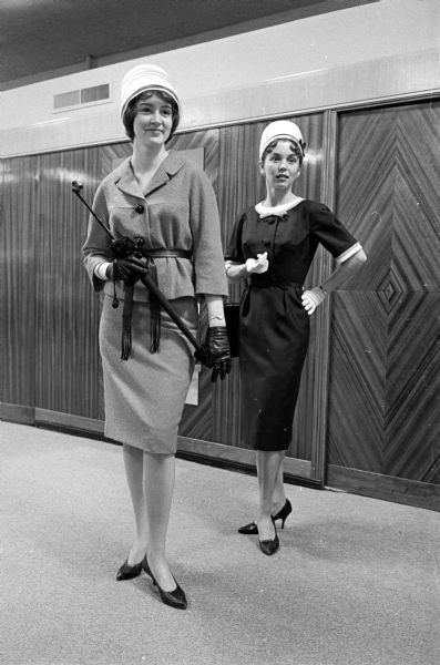 Two women modeling dresses and hats. The original caption states: "Two of the models for Saturday's benefit dessert bridge party, fashion show, and bake sale of Alpha Phi sorority are Miss Joyce Pandolfi, Riverside, Ill., left, and Mrs. R. W. Bartel, 402 Palomino Lane. Proceeds at the chapter house, 28 Langdon St., will go to the sorority's national philanthropy, a cardiac aid fund, and the heart research foundation at the University of Wisconsin."