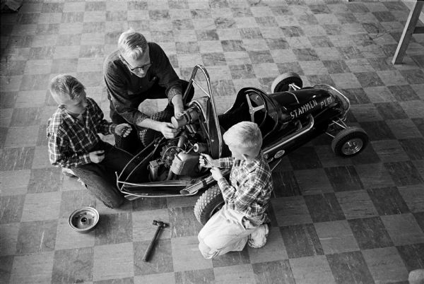 Randy, left, and Mike Stammen helping their father Earl make final adjustments on their racer in preparation for the National Championships of the Quarter Midgets of America Racing Association.