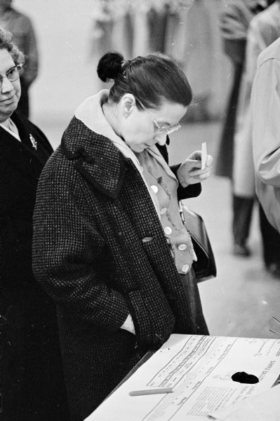 "We Saw You Performing Civic Duty" at Midvale School. A voter is shown studying a sample ballot at the 1961 spring election.