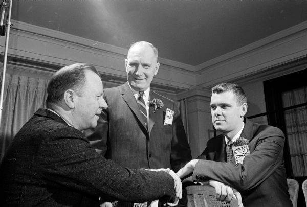 Madison mayor Harold E. Hanson, standing, chatting with Norman A. Allheiser, left, of the University of Wisconsin Management Institute and George A. Nelson of Ohio Chemical and Surgical Equipment Company at the ninth annual Management Night held at the Loraine Hotel.