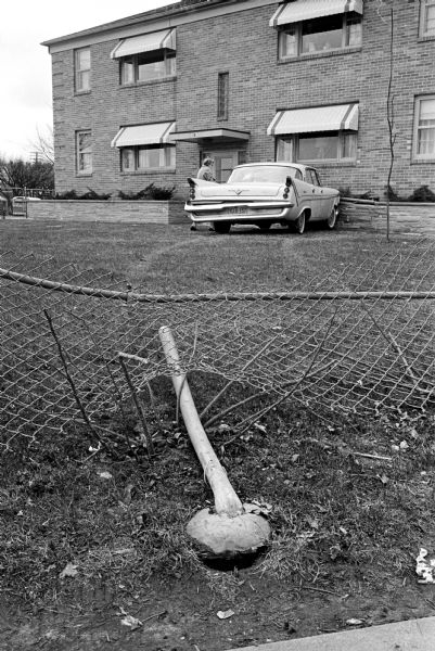 Mrs. Lavern (Edith) Clark walking away from her car that was knocked out of control on Milwaukee Street by another car. It crashed through a fence and into a retaining wall at the Gunderson Apartments at Milwaukee Street and Fair Oaks Avenue.