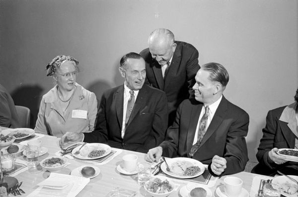Individuals at the head table for the first Women's Day sponsored by the Wisconsin Alumni Association include, (seated) left to right: Professor Helen C. White of the University of Wisconsin English Department; Don Anderson who is president of the Alumni Association and publisher of the Wisconsin State Journal; and Professor Conrad A. Elvehjem. Standing in back is John Berge who is the executive director of the Alumni Association.