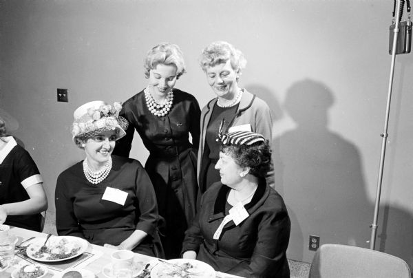 Four ladies attending the first Women's Day sponsored by the Wisconsin Alumni Association. Seated are Mrs. J. Martin Klotsche, wife of the provost of the University of Wisconsin-Milwaukee (left); and Mrs. Conrad A. Elvehjem, wife of the University of Wisconsin president. Standing are Gail Guthrie, a senior University of Wisconsin student from Lac du Flambeau (left); and Margaret Russell, a member of the university Board of Visitors.