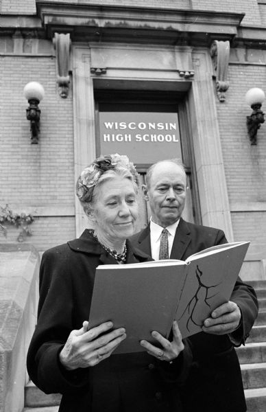 Two early graduates of Wisconsin High school admiring the 1961 school yearbook at a reception marking the school's 50th anniversary. They are Ruth Noland, class of 1913, and Milo K. Swanton, class of 1912.