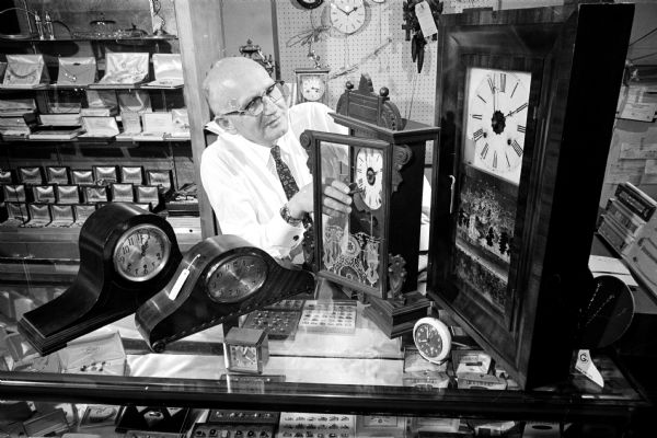 Charles J. Seipel resets clocks in his jewelry store at 1803 Monroe Street prior to the switch to daylight savings time.