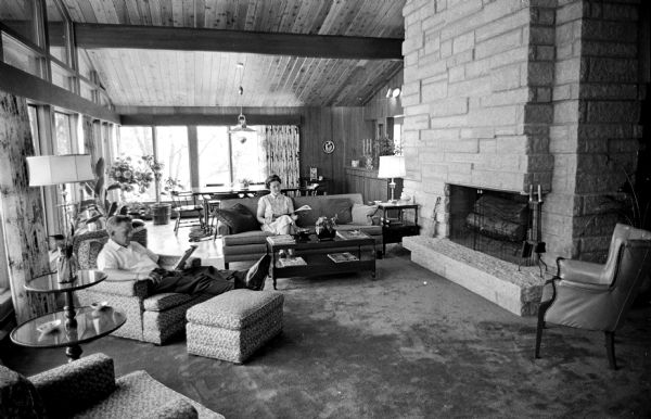Stanley Herrling and his wife relaxing in the living room of their farm home. Featured is a large limestone fireplace. This is one of a series of photographs of a rural Cross Plains farm which was purchased 6 years ago by Stanley Herrling and returned to family ownership after a period of 40 years. The Herrling family has worked to build a comfortable home and restore the farm's soil, forest, and wildlife.